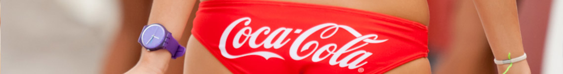 Czerwony strój kąpielowy z logo Coca-Cola i purpurowy zegarek na nadgarstku.